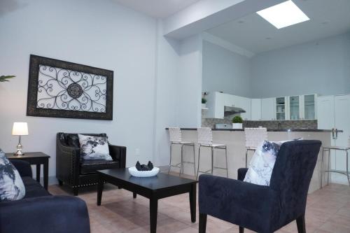 a living room with chairs and a table and a kitchen at New York view 38 in West New York