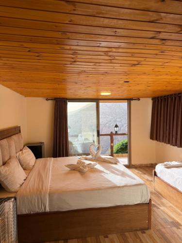 a bedroom with a large bed and a large window at Dana in Tufailah