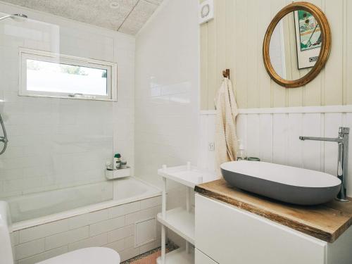 a white bathroom with a tub and a sink at 4 star holiday home in Slagelse in Slagelse