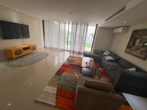 a living room with a couch and a tv at Waterfront - B luxury in Dakar