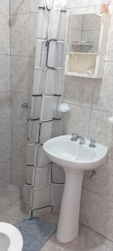 a bathroom with a white sink and a shower at Luci Alojamiento in Uspallata