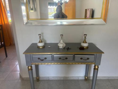 a table with vases on top of it with a mirror at Vacacional rent in Boca Chica