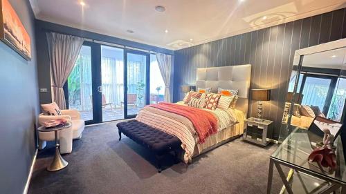 a bedroom with a bed and a chair and a window at La Maison Barwon in Connewarre