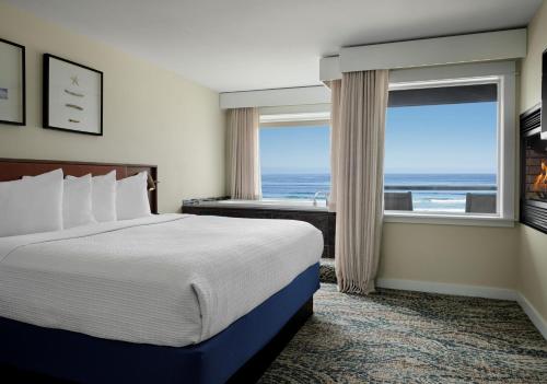 a hotel room with a bed and a large window at Starfish Manor Oceanfront Hotel in Lincoln City