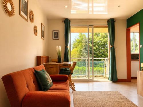 a living room with a couch and a large window at Appartement thème jungle in Avallon