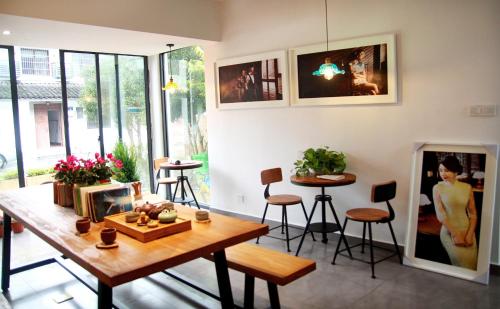 a living room with a wooden table and chairs at Hangzhou Qiushan Uncle's Photography Inn in Hangzhou