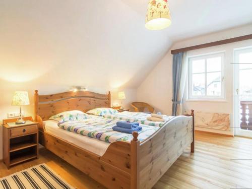 a bedroom with a wooden bed and a window at Almenblick in Kleblach