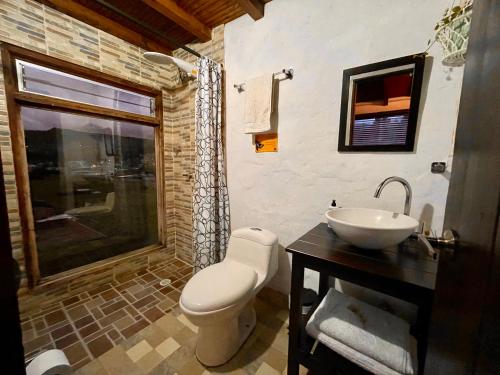 a bathroom with a toilet and a sink at Hostal Casa Lantana in Suesca