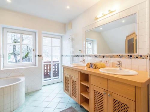 a bathroom with a sink and a tub and a mirror at Almenblick in Kleblach