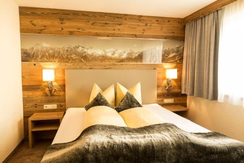 ラディスにあるApart-Pension Berglandの木製の壁のベッドルーム1室(大型ベッド1台付)