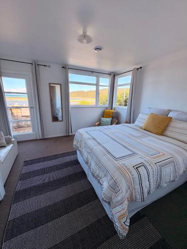 a large bedroom with a large bed with windows at Windy Garden in Marahau