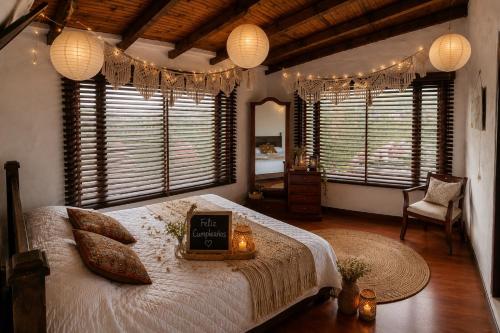 a bedroom with a bed with a clock on it at Hostal Casa Lantana in Suesca