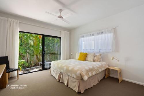 a bedroom with a bed and a large window at Bessou in Charlotte Bay
