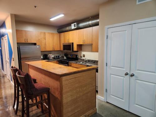 a kitchen with wooden cabinets and a counter with chairs at Just like home in Atlanta