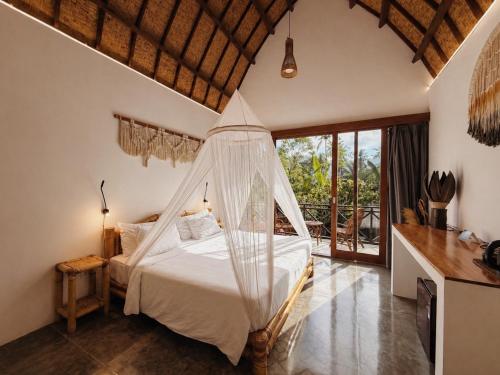 a bedroom with a bed with mosquito net at Martas Windows in Kuta Lombok