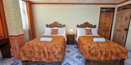 a hotel room with two beds with orange sheets at Sunset - Puesta de Sol in Uyuni