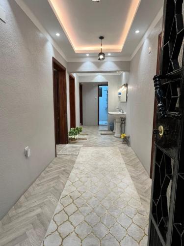 a hallway of a hotel with a sink and a door at Sultana Apartments in Abha