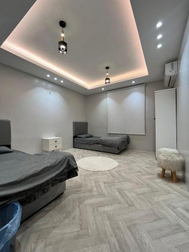 a bedroom with a bed and a white wall at Sultana Apartments in Abha