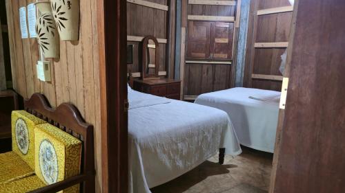 ein kleines Zimmer mit zwei Betten und einem Spiegel in der Unterkunft Hotel Nueva Alianza in Frontera Corozal