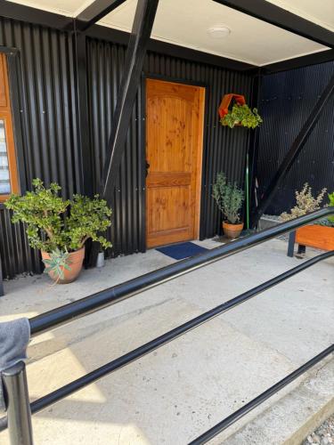 a front door of a house with potted plants at departamento central in Valdivia