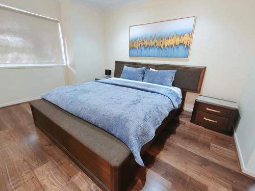 a bedroom with a large bed with blue pillows at Modern Retreat by Underwood market&51 Area in Kuraby