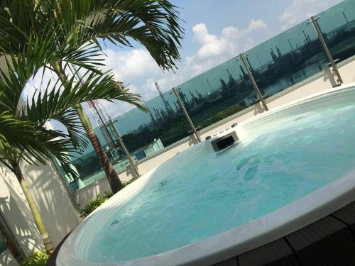 a large swimming pool with a palm tree and the ocean at Hotel Titanium Plaza in Barrancabermeja
