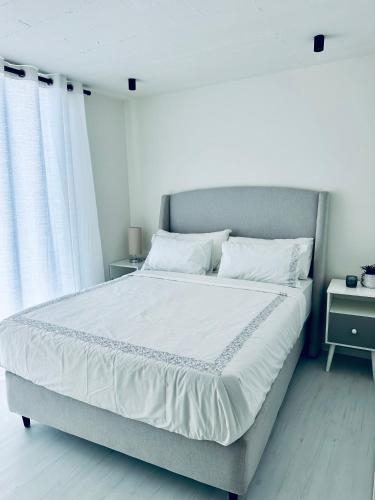 a bed with white sheets and pillows in a bedroom at Casa RuMat in Swakopmund