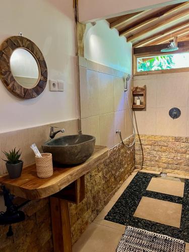 a bathroom with a sink and a mirror at Beda gaya ecolodge Rangsot 3 in Tanjung