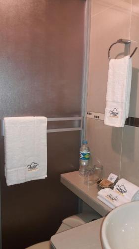 a bathroom with white towels hanging on a wall at Picos House MachuPicchu in Machu Picchu