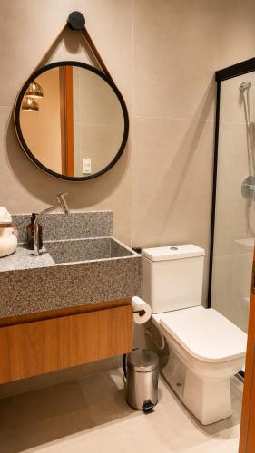 a bathroom with a sink and a toilet and a mirror at Estúdio Premium em Japaratinga - Unidade Coralli - Vila Naluri in Japaratinga
