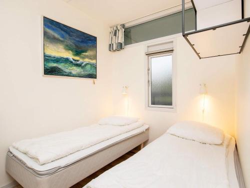 two beds in a room with a painting on the wall at Home in Faaborg with swimming pool in Faaborg