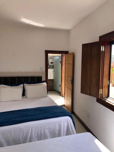 a bedroom with two beds and a window at Cantinho do Rosário in Diamantina