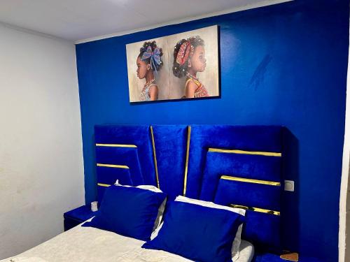 a blue bedroom with a bed with blue walls at Hôtel Famigni in Douala