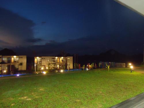 a grassy yard with buildings at night at Lakeview Terrace Resort Pengerang in Pengerang