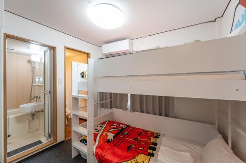 a bedroom with two bunk beds and a bathroom at Namba 5min by subway OYASUMI Manga HOTEL 24 hours Self-check-in Japanese-Style hotel in Osaka