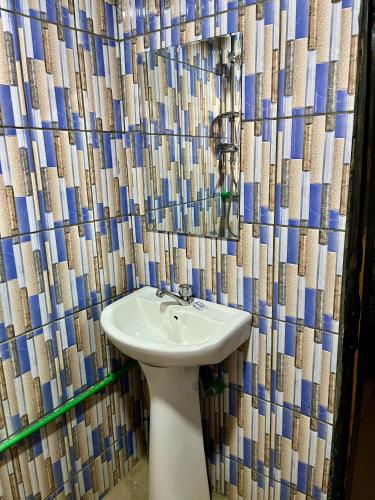 a bathroom with a sink and a shower curtain at Hôtel Famigni in Douala