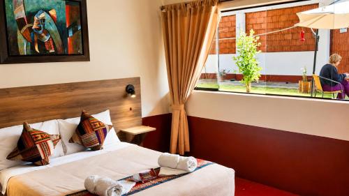 a hotel room with two beds and a window at Chaska Valle Green in Urubamba