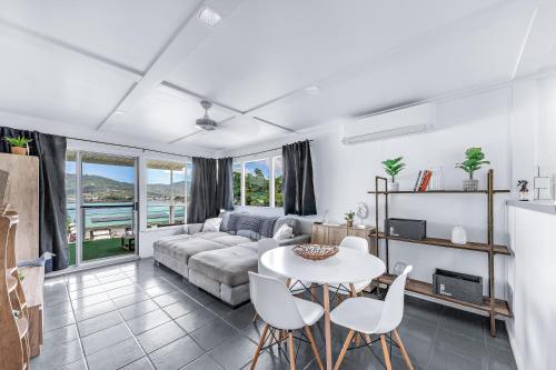 a living room with a couch and a table and chairs at Hillcrest Harmony in Airlie Beach