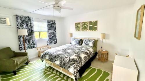 a bedroom with a bed and a green chair at Holualoa Gardens 204 in Kailua-Kona