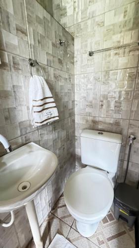 a bathroom with a white toilet and a sink at Casarão da ilha in Ilha Cotejuba