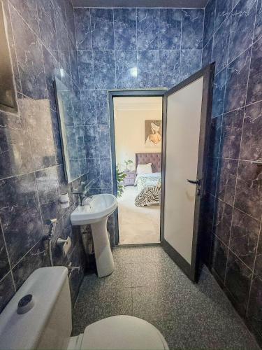 a bathroom with a toilet and a sink and a bathroom with a bed at CATU Colors and Comfort, A Choice of Studios in Dakar in Dakar