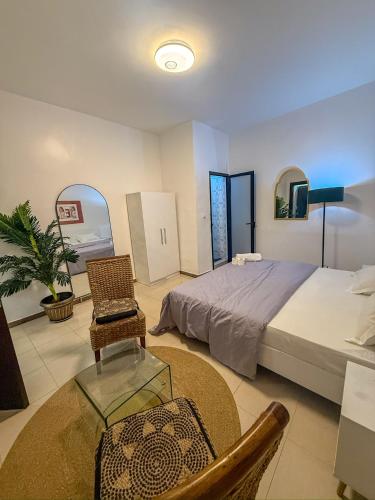 a bedroom with a bed and a table and a chair at CATU Colors and Comfort, A Choice of Studios in Dakar in Dakar