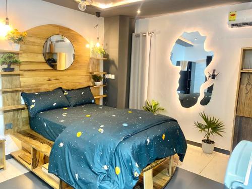 a bedroom with a bed with a blue comforter at Cozy Studio Apartment in Accra in Accra