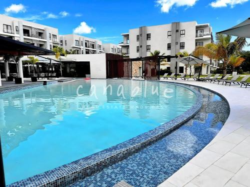 a large swimming pool in front of a building at Vista Cana punta cana beach Paradise Pool & Lake golf Condo in Punta Cana