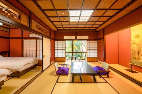 a room with a bed and a table and chairs at Hoshi in Komatsu