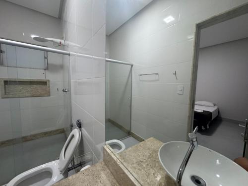 a bathroom with a sink and a toilet and a mirror at Pousada In'capitólio in Capitólio