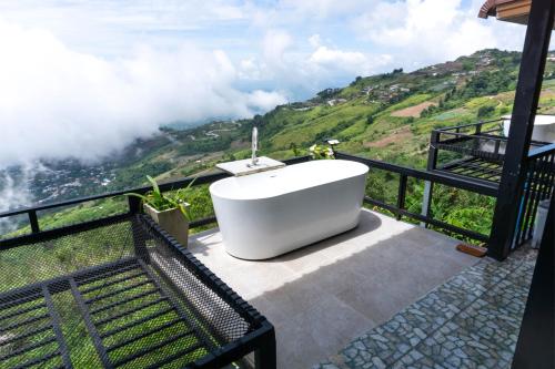 a bath tub on a balcony with a view of a mountain at บ้านนุสรา รีสอร์ท ภูทับเบิก in Ban Maeo Thap Boek