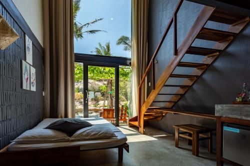 a bedroom with a bed and a staircase at Rock Bay by Chành Rành in Vĩnh Hy