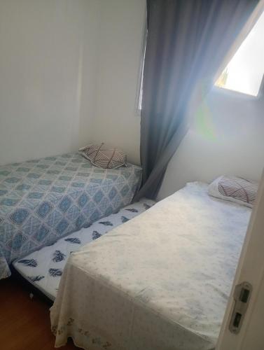 a bedroom with two beds and a window at Apartamento próximo arena mrv, expominas e Puc in Belo Horizonte