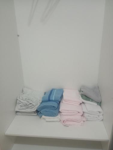 a shelf filled with different colored towels in a closet at Apartamento próximo arena mrv, expominas e Puc in Belo Horizonte